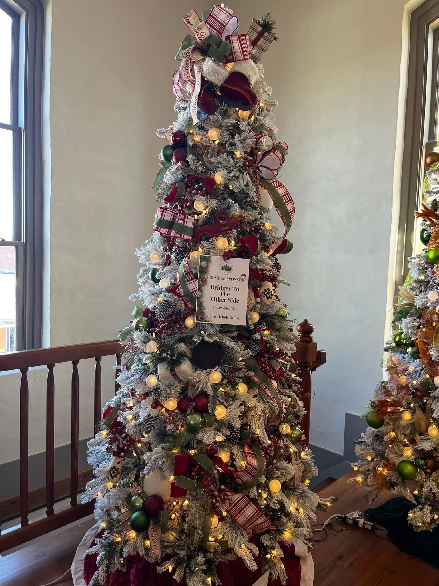 A traditional red, green, and plaid premium tree filled with farmhouse Christmas charm at the WNC Festival of Trees in Hayesville, North Carolina