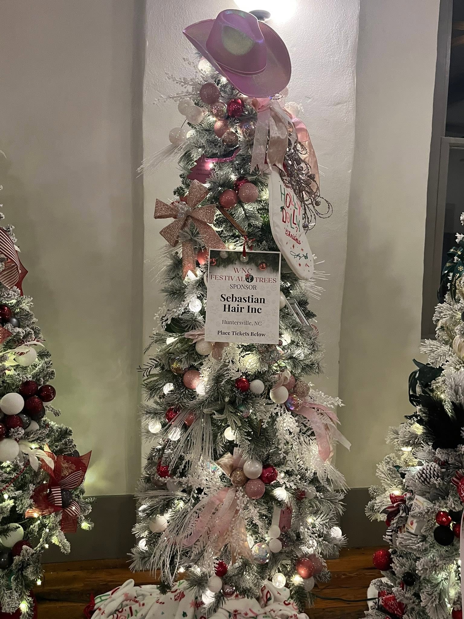 A glamorous pink-and-white tree topped with a playful cowgirl hat at the WNC Festival of Trees in Hayesville, North Carolina