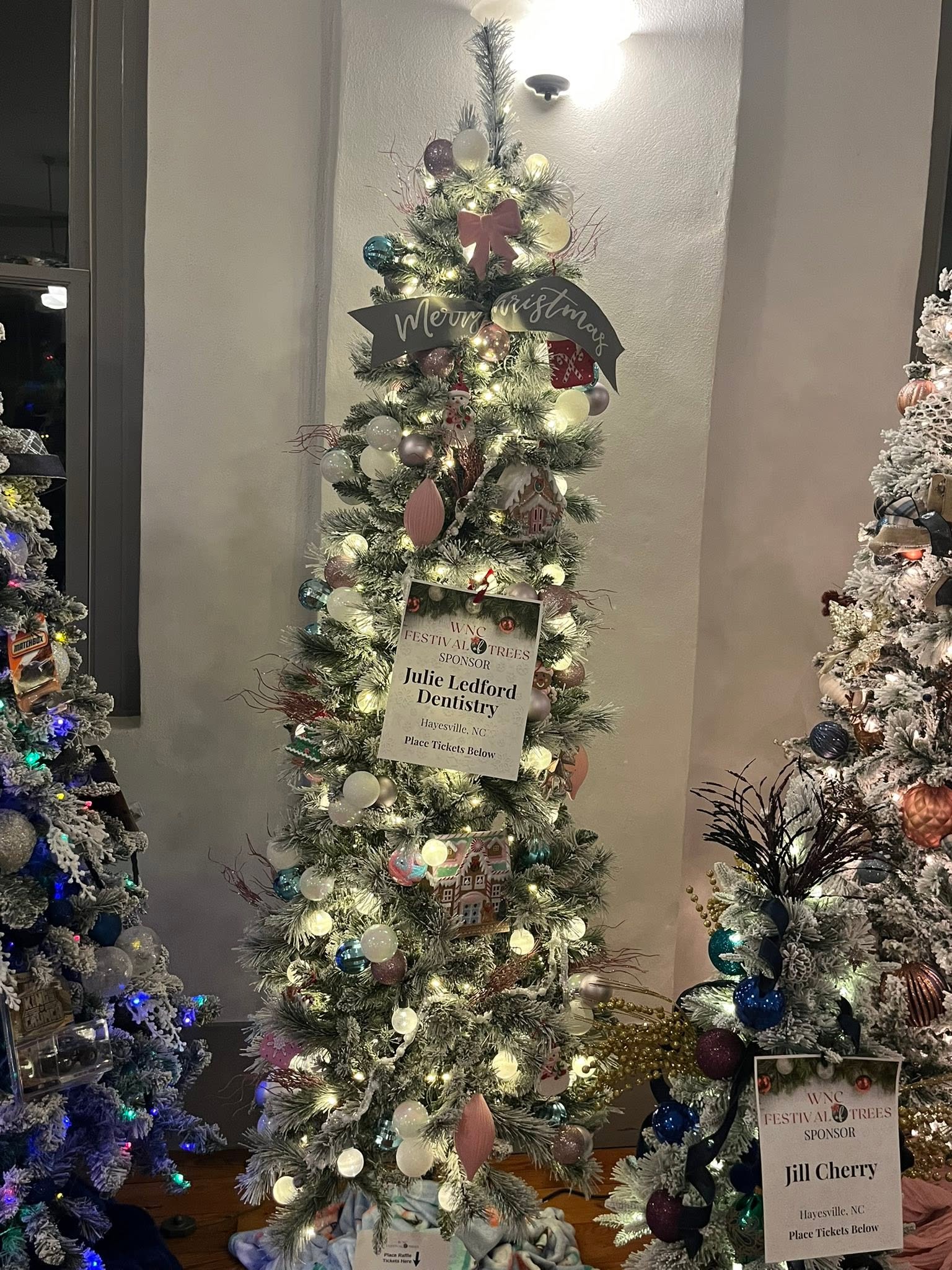 A sweet pastel Christmas tree filled with gingerbread charm and warm light at the WNC Festival of Trees in Hayesville, North Carolina