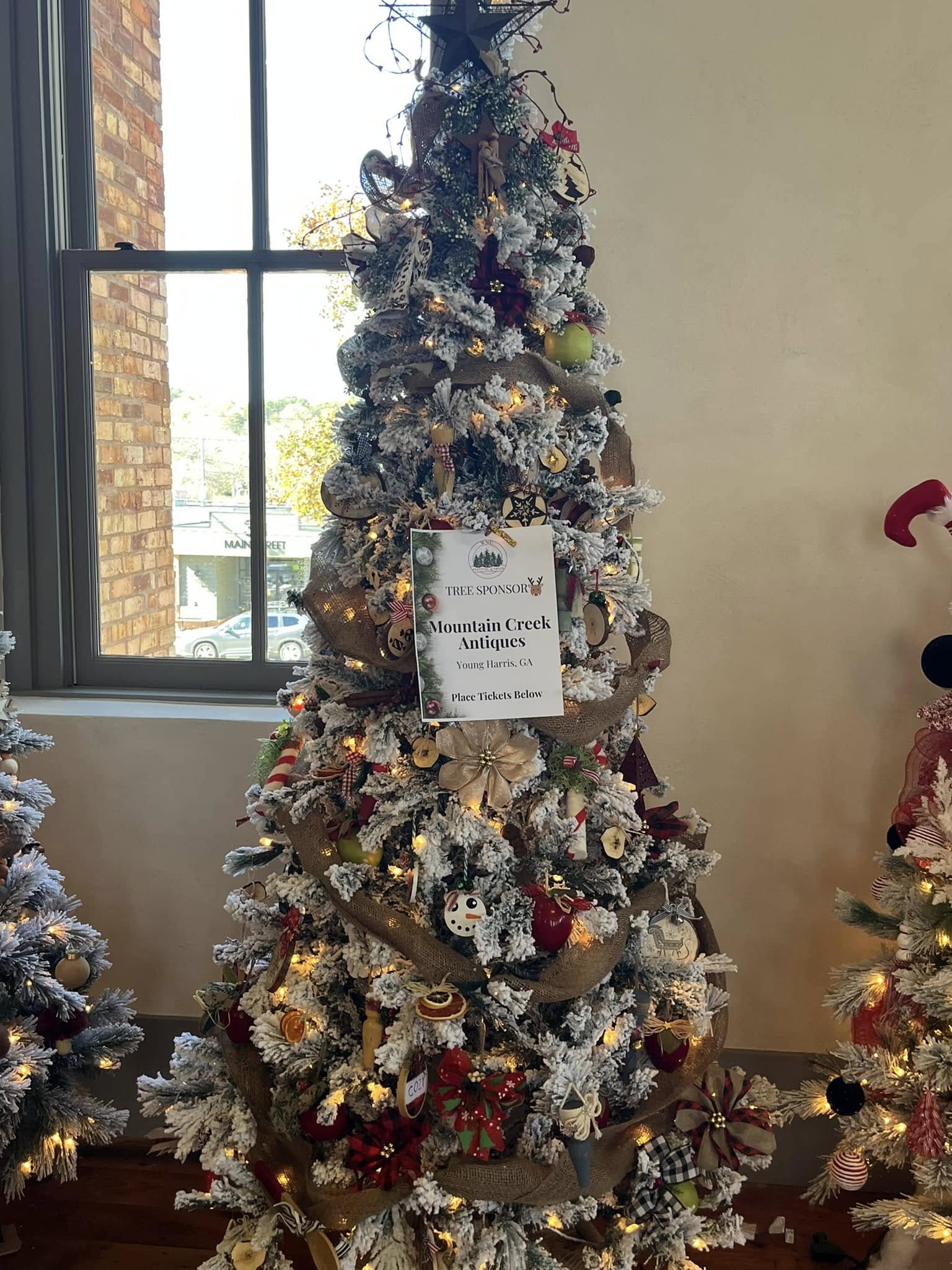 Snowy rustic tree wrapped in burlap and nostalgic ornaments at the WNC Festival of Trees in Hayesville, North Carolina
