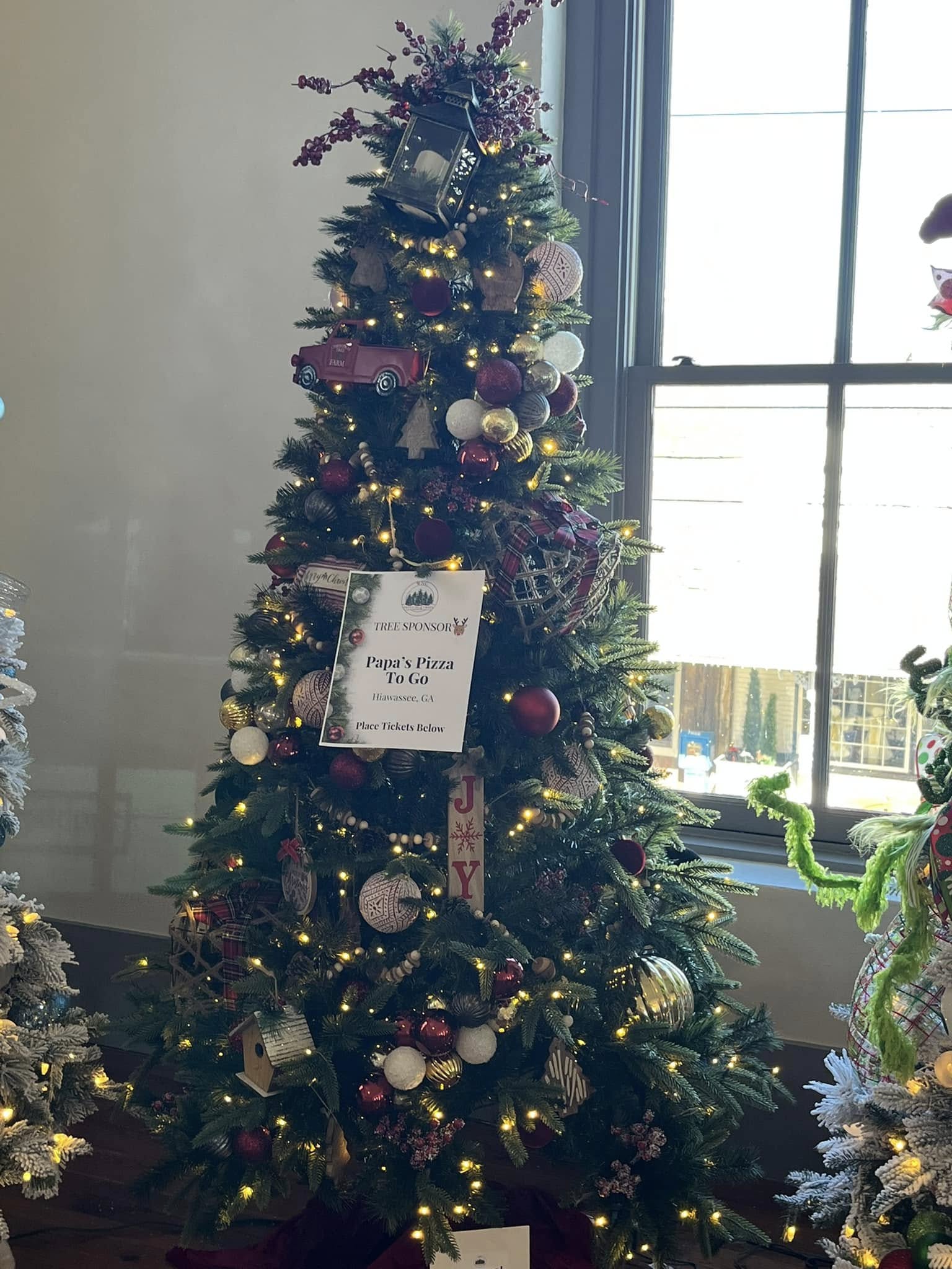 Warm farmhouse Christmas tree with burgundy and plaid accents at the WNC Festival of Trees in Hayesville, North Carolina